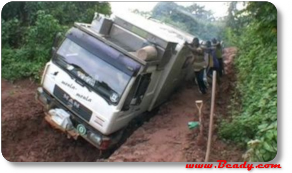 overland truck on its side with local helping, africa