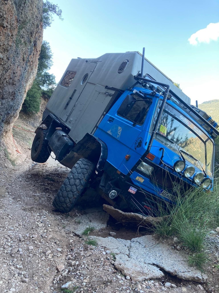 overland truck on narrow road, falls over the side