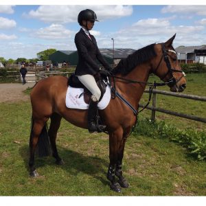 Chloe And Clannad before jumping the BN/90cm open in her Equestrian world of Maynooth saddle cloth and KEP hat.