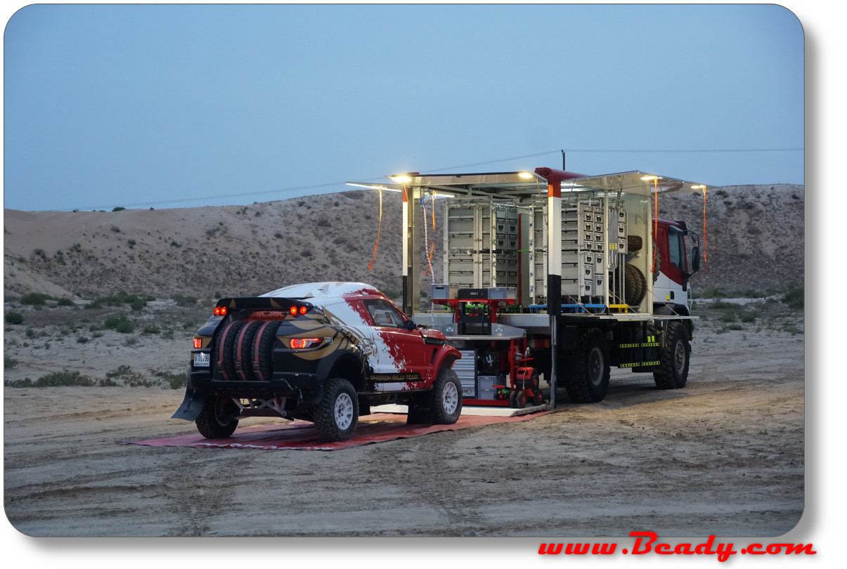 Range rover race car in desert wtih support truck official factory car